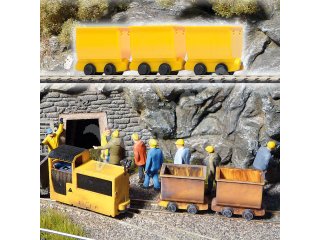 3 gelbe Bergwerksloren. Zugbildung mit weiteren Loren und der Grub
